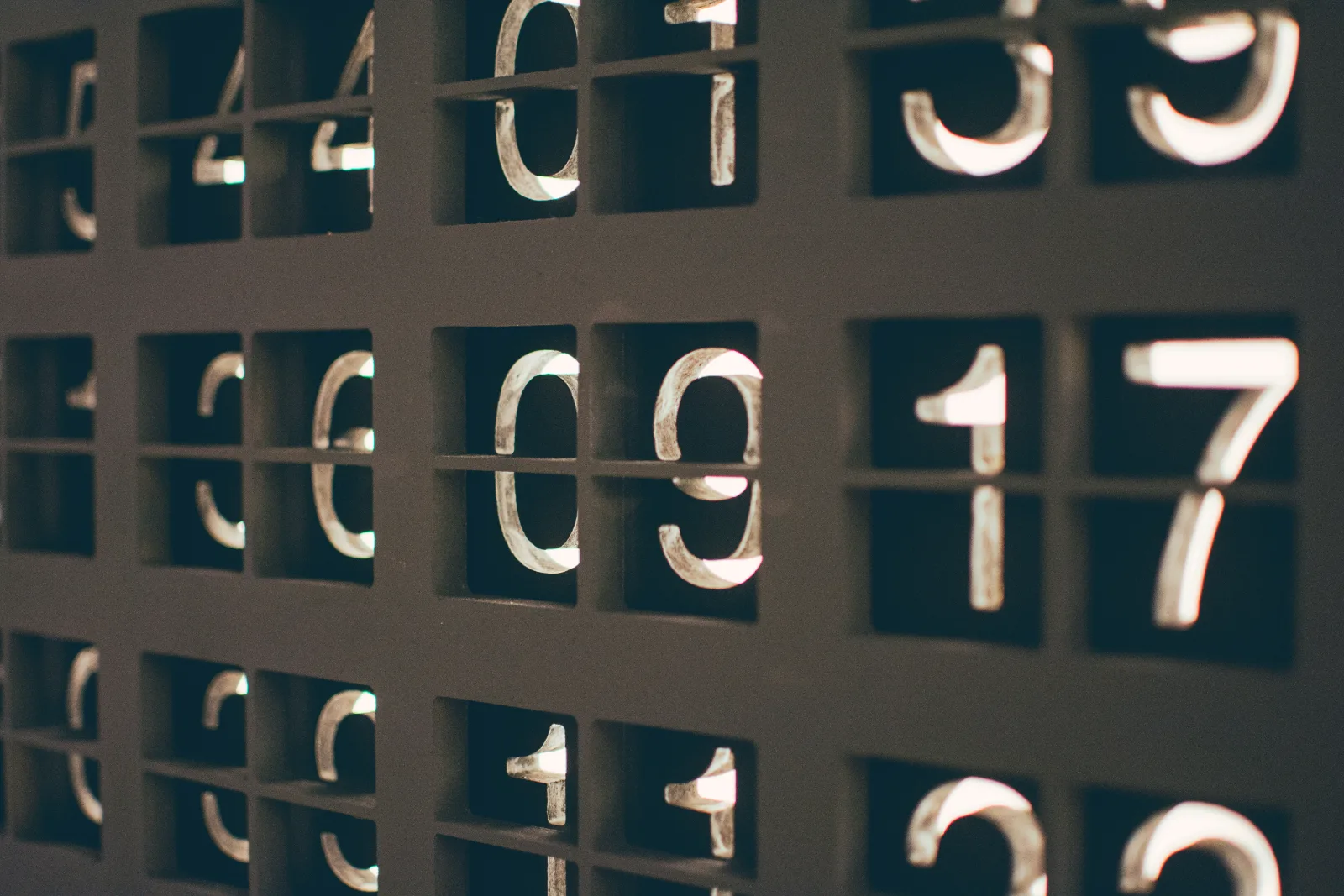 Gros plan sur une rangée de chiffres métalliques rétroéclairés sur un tableau compteur.